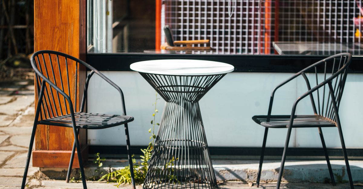 stylish outdoor cafe setup featuring modern metal chairs and a round table